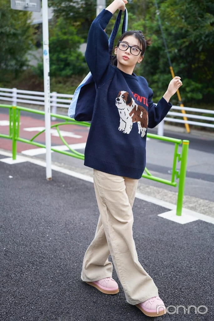 犬モチーフのニットを着て横を向く出口夏希