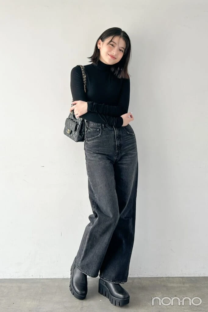 黒いタートルと黒のデニムパンツの出口夏希