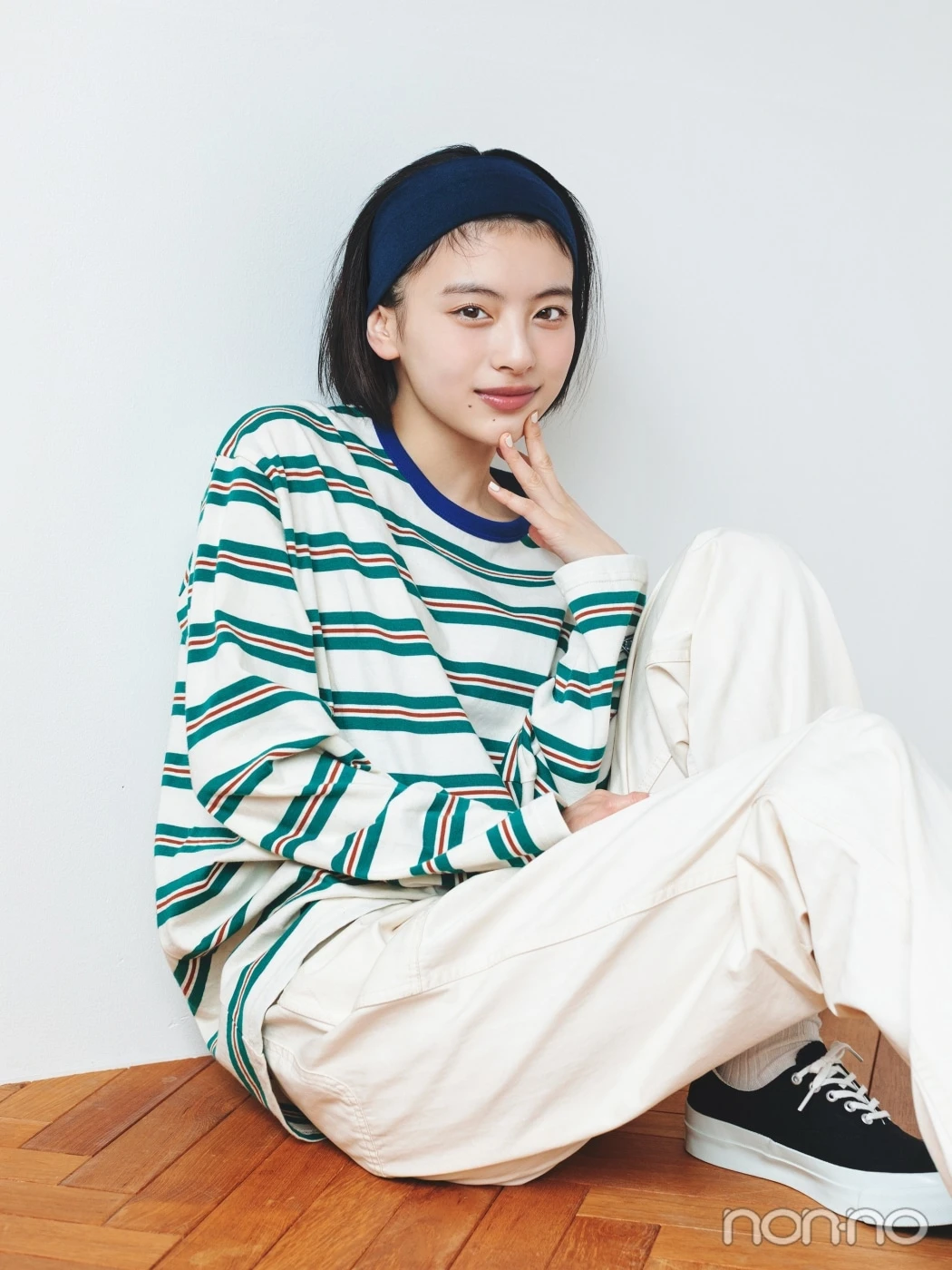 紺色のヘアバンドをして座る出口夏希