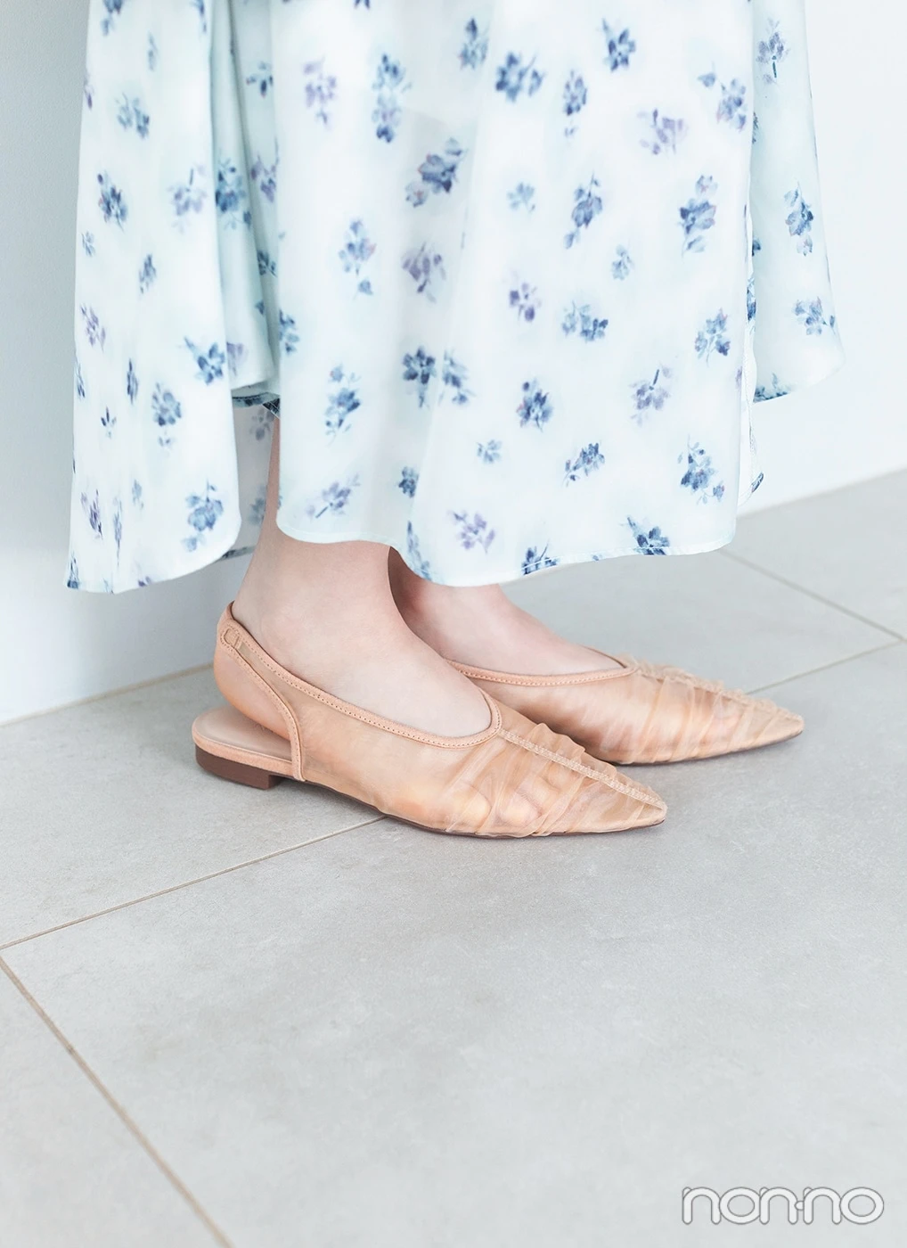 ベージュのメッシュのパンプスを履いた足元