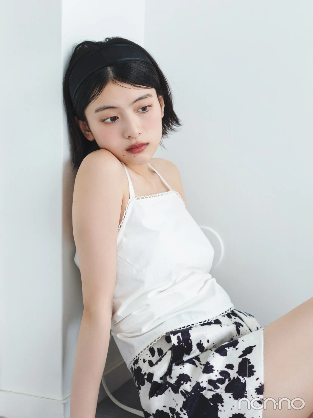 白いキャミソールに黒いカチューシャをつけて座る出口夏希