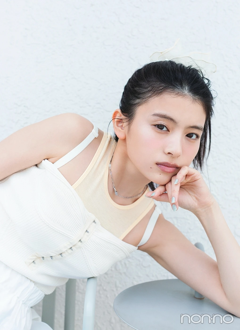 白いキャミを着てテーブルにひじをつく出口夏希のアップ