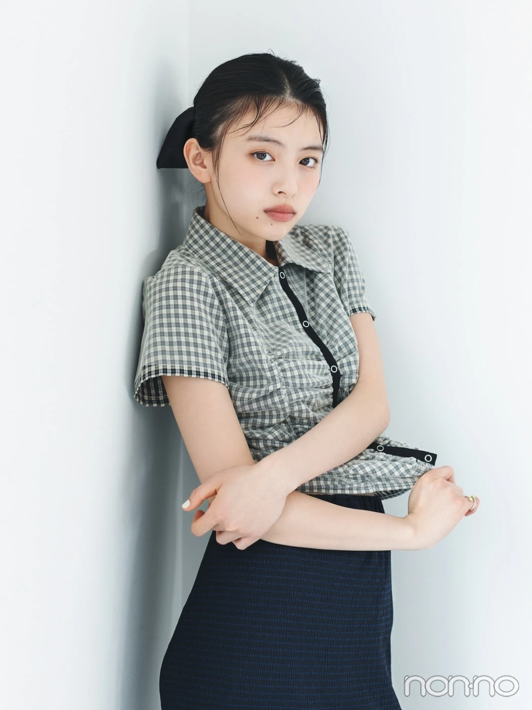 チェックシャツを着て髪を結んだ出口夏希、バストアップ