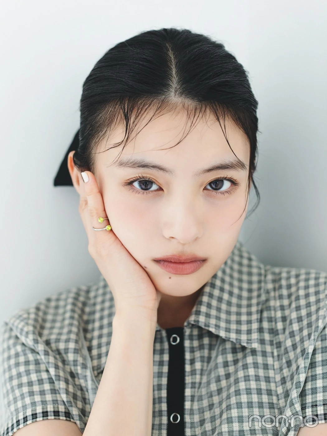 チェックシャツを着て髪を結んだ出口夏希の顔のアップ
