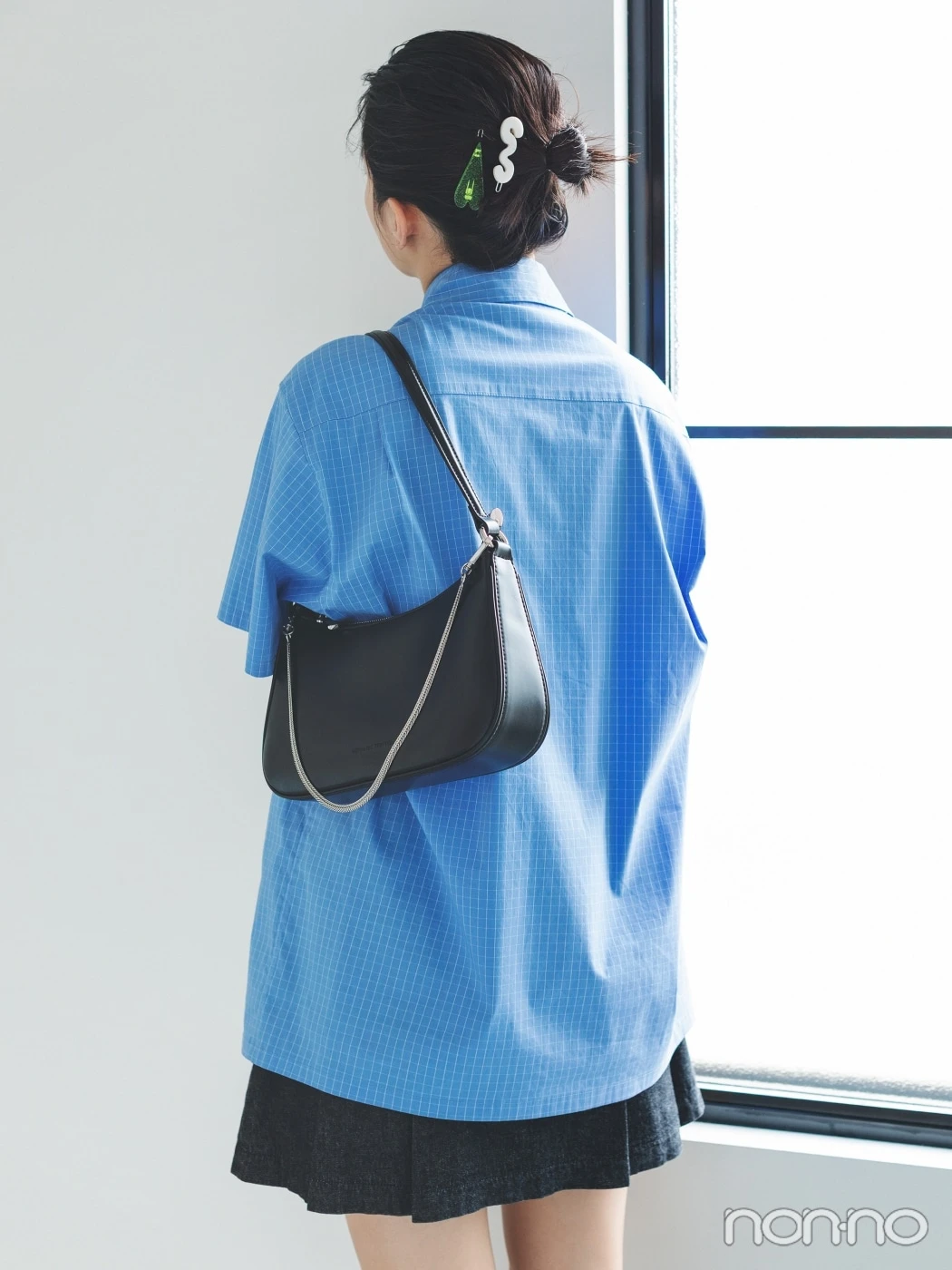 青いシャツを着た出口夏希の後ろ姿