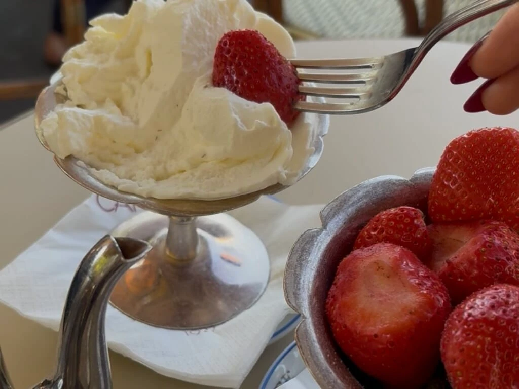 〈Carette（カレット）〉のいちごの盛り合わせ「Coupe de fruits rouges frais」にシャンティを添えている様子
