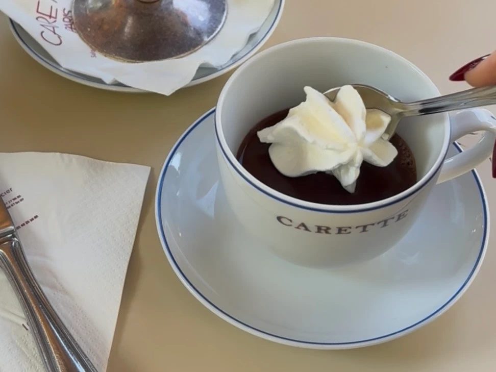 〈Carette（カレット）〉のショコラショーにシャンティを添えている様子