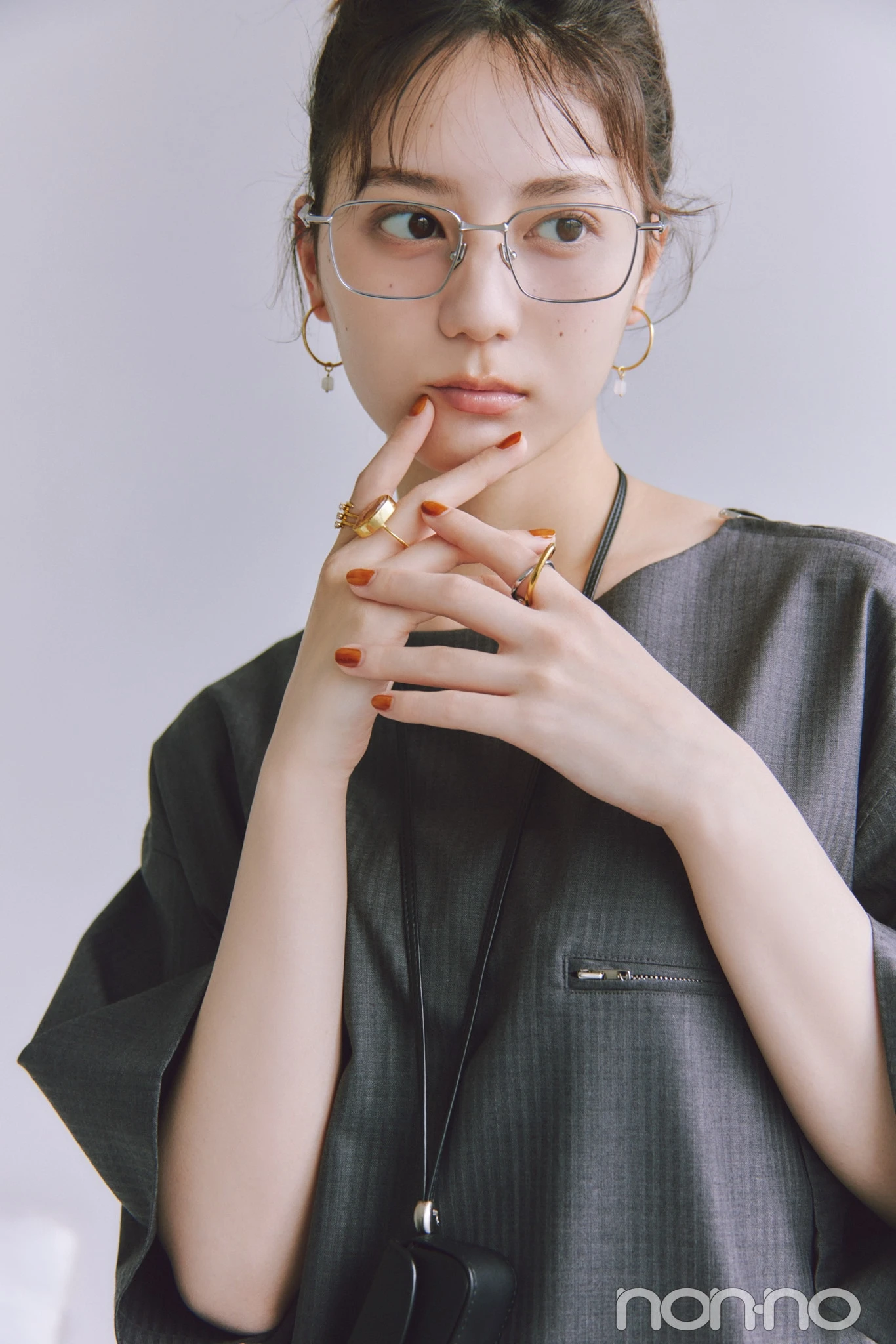 シルバーのスクエアメガネとゴールドのアクセをつけた小坂菜緒