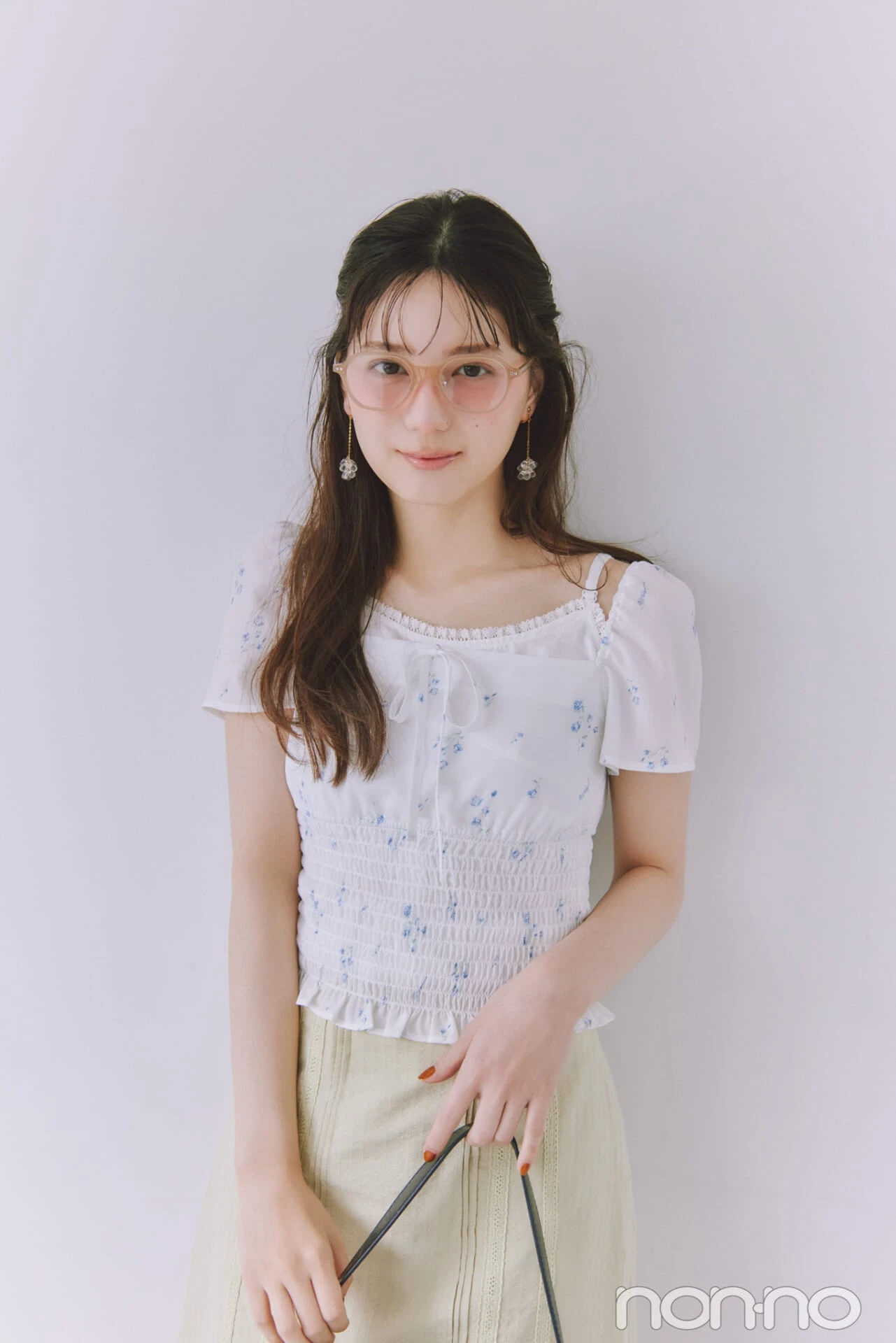 ニュアンスカラーフレームメガネをかけてフェミニンコーデを着る小坂菜緒