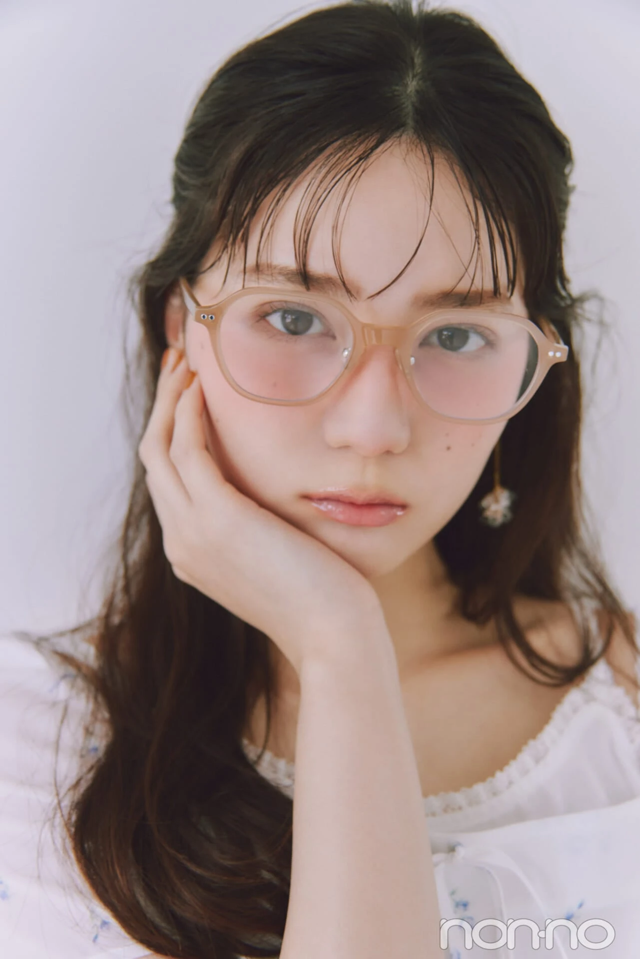 ニュアンスカラーフレームメガネをかけてベージュチークを塗った小坂菜緒