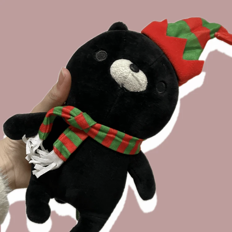 黒猫のぬいぐるみがゴンチャホリデーシーズンジンジャーブレッドマンボトルが付けていたマフラーと帽子を身につけている画像