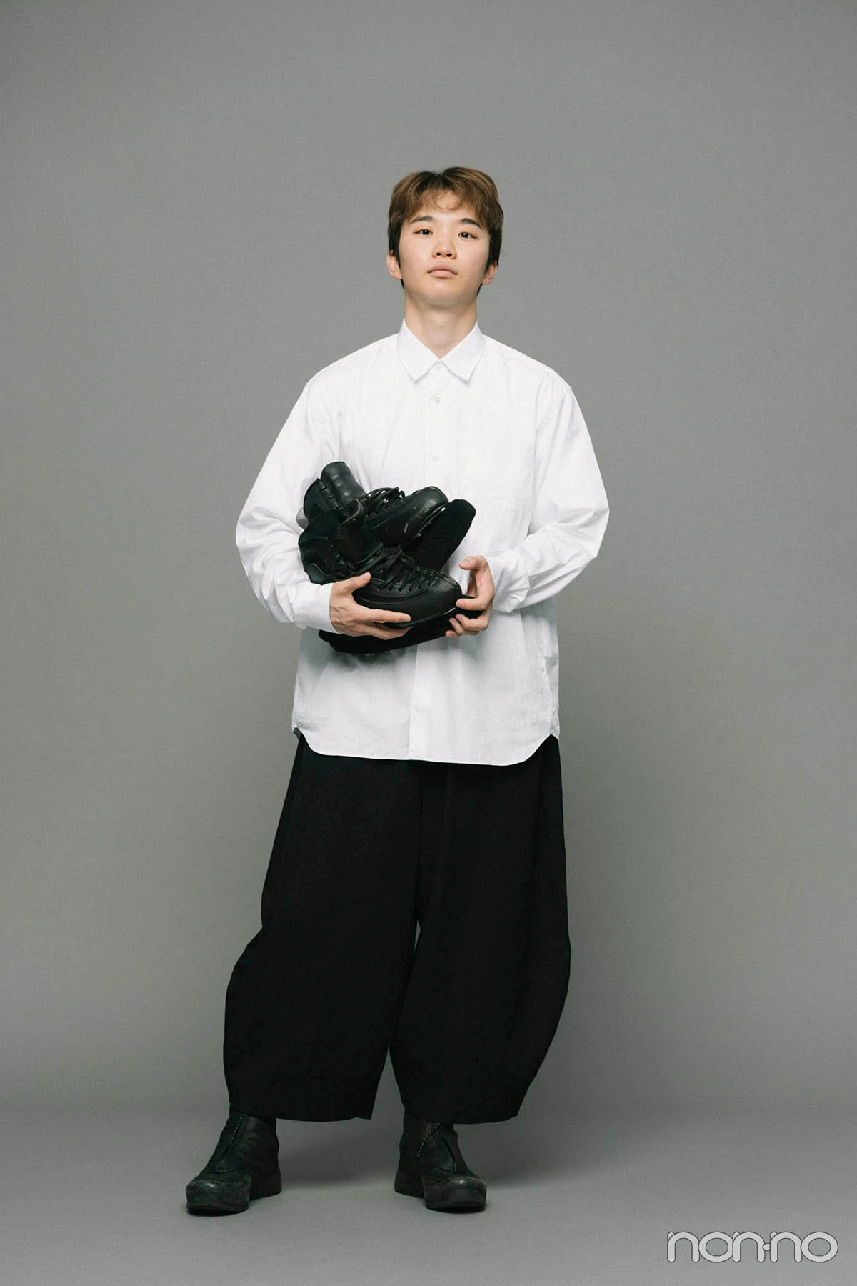 フィギュアスケート靴を手に立つ友野一希さんのノンノインタビューカット