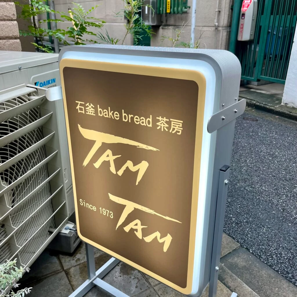 神保町駅A7出口を出てすぐ、「石釜bake bread 茶房 TAMTAM」の外看板の写真。