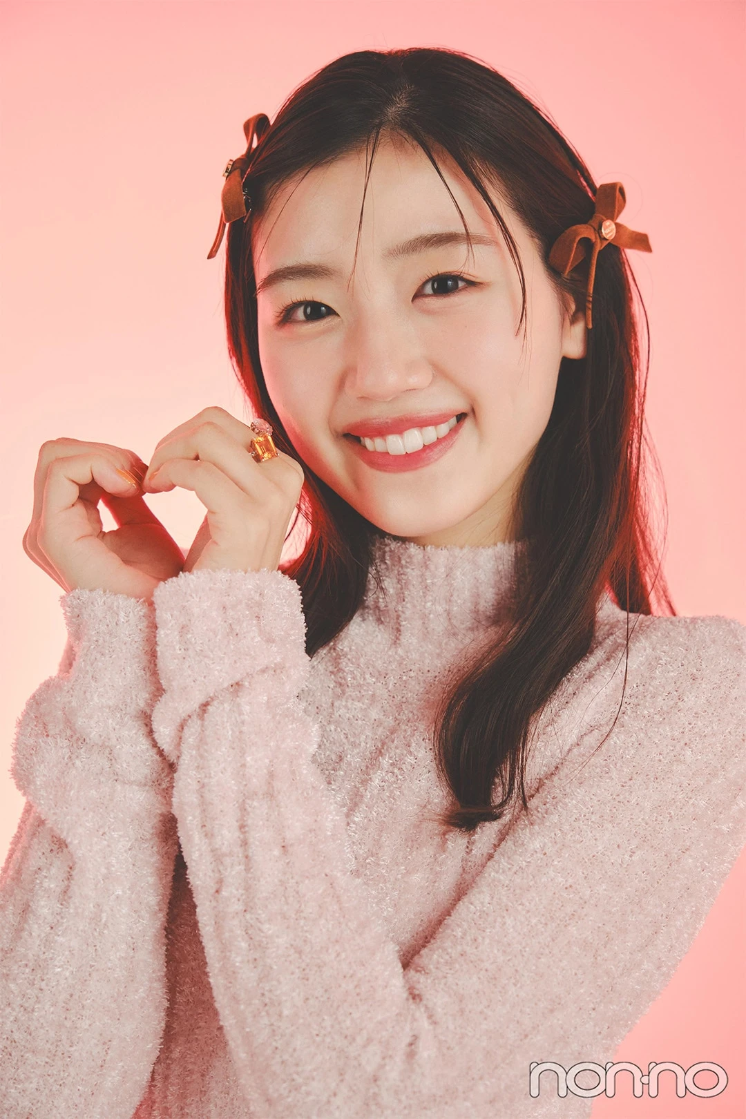 ピンクのニットを着て顔の横でハートを作る佐々木美玲