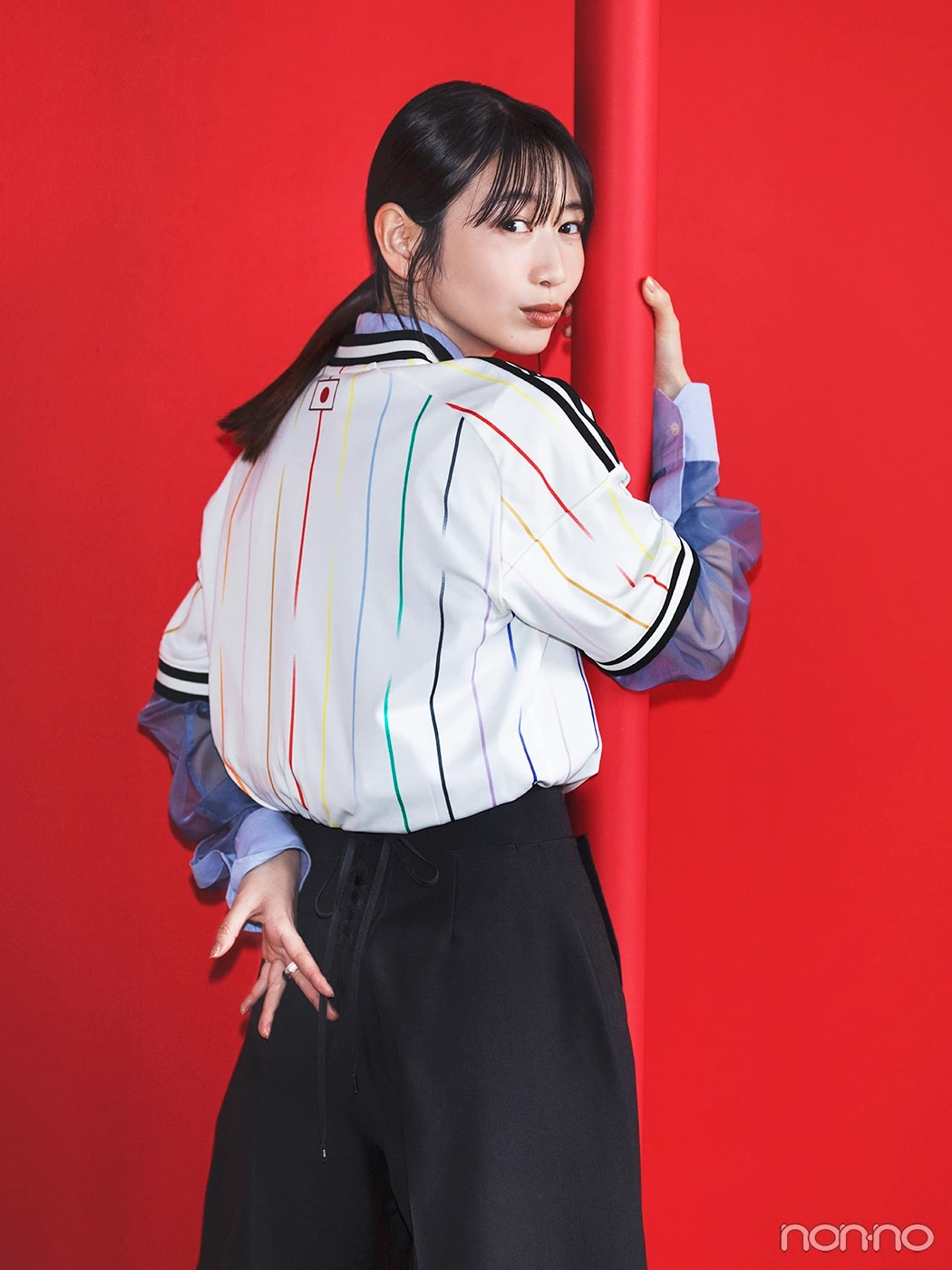 サッカー日本代表アウェイユニフォームとブルーシャツを重ねた岡本夏美の後ろ姿