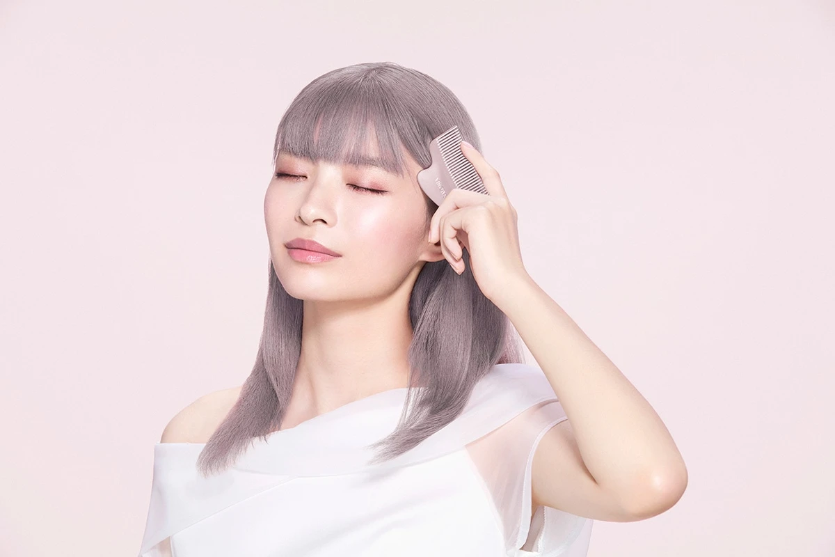 かっさで頭皮ケアをしている女性
