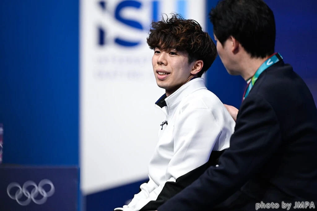 ミラノ五輪フィギュアでショートプログラム後、佐藤駿(さとうしゅん)選手がキス&クライに座る様子